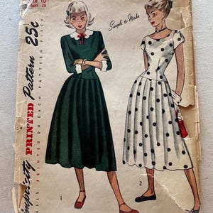 May include: Vintage Simplicity sewing pattern for a dress, featuring two illustrations of women wearing the dress. The pattern is for size 10, bust 28, and costs 25 cents. The text "Simplicity Printed Pattern" is printed in red on the front of the pattern.