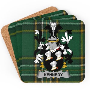 Puede incluir: Juego de cuatro posavasos de tartán verde, blanco y amarillo con un escudo negro y blanco y la palabra "KENNEDY" en una pancarta plateada.