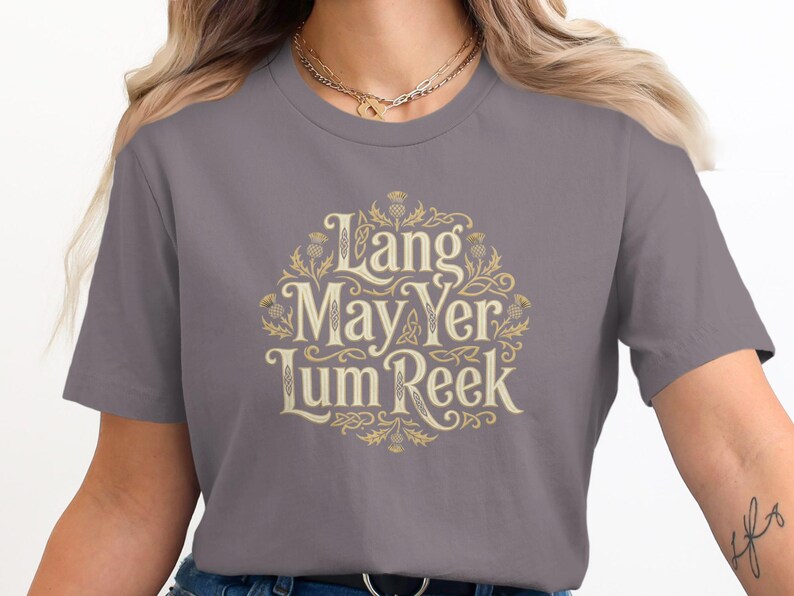 Gray t-shirt with "Lang May Yer Lum Reek" text in ornate gold lettering.
