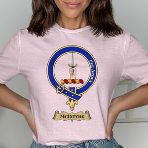 Pink t-shirt with McIntyre clan crest, featuring a sword and motto.