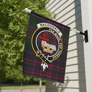 May include: A red, green, and black tartan flag with a crest featuring a hand holding a cross and a crown. The crest is surrounded by a circle with the text "MACDONALD PER MARE PER TERRAS".