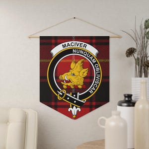 May include: A wall hanging displaying the MacIver clan crest. The design includes a yellow boar's head on a red circle, set against a red and black tartan background. The banner is suspended from a wooden rod.