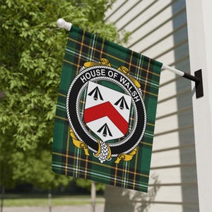 May include: A rectangular flag featuring a green, black, and yellow tartan pattern. Centered on the flag is a circular black belt emblem with the text HOUSE OF WALSH, surrounding a white shield with a red chevron and three black arrowheads.