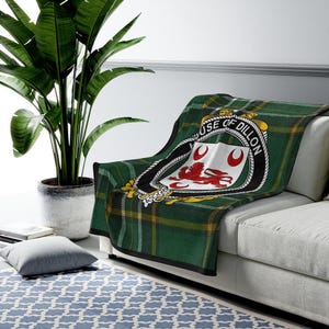 Peut inclure: Jeté de canapé en tartan vert, jaune et noir avec un blason représentant un lion rouge et le texte "House of Dillon".