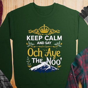 May include: Green sweatshirt with a gold crown and the text "Keep Calm and Say Och Aye The Noo'" printed on the front.