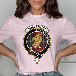 Pink t-shirt with Fullerton Lux in Tenebris clan crest badge.