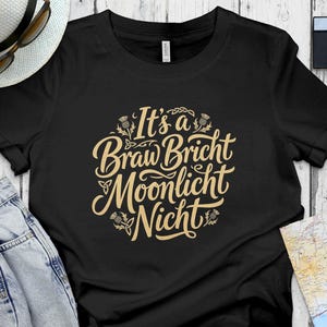Black t-shirt with "It's a Braw Bricht Moonlicht Nicht" text in beige.