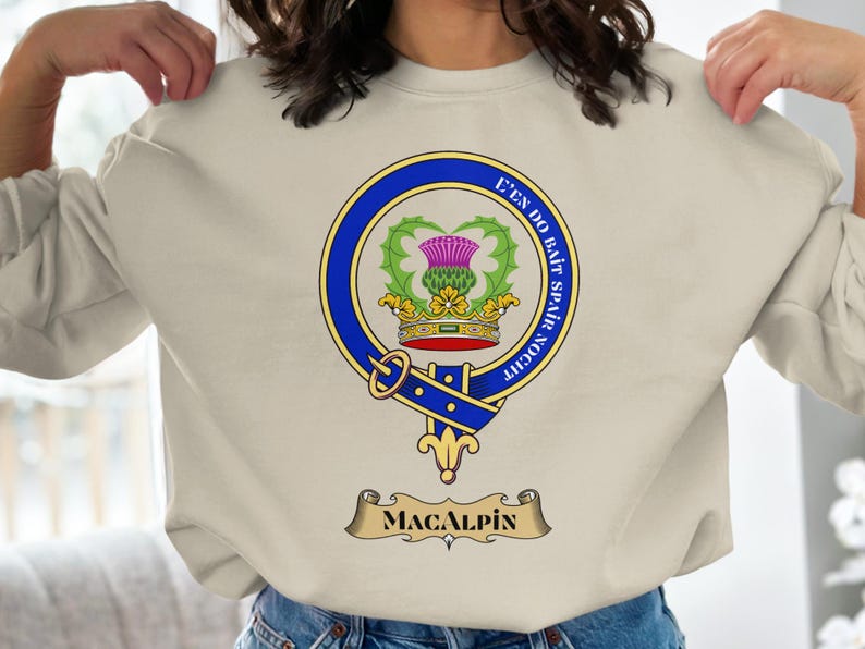 Clan MacAlpin crest featuring a thistle and motto on a cream sweatshirt.