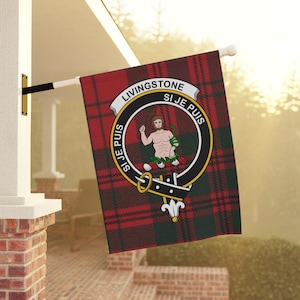 May include: A red, black, and green tartan flag with a crest featuring a man holding a club and the text "Livingstone Si Je Puis" in a circle.