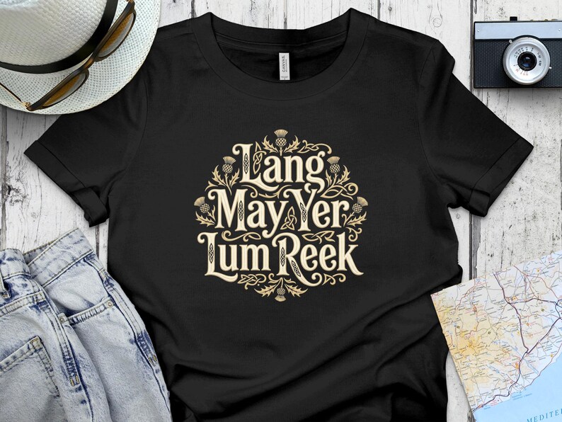Black t-shirt with "Lang May Yer Lum Reek" in ornate lettering and thistle accents.