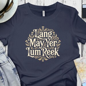 Navy t-shirt with "Lang May Yer Lum Reek" in ornate gold lettering.