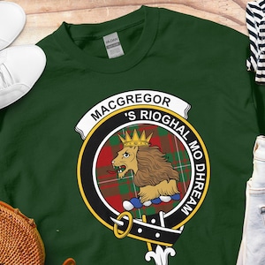 May include: Green sweatshirt with a circular crest featuring a lion, a crown, and the text "MacGregor 'S Rioghal Mo Dhream".