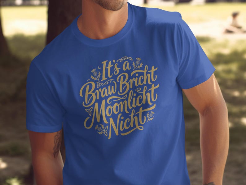 Blue t-shirt with gold Celtic knot lettering that reads "It's a Braw Bricht Moonlight Nicht".