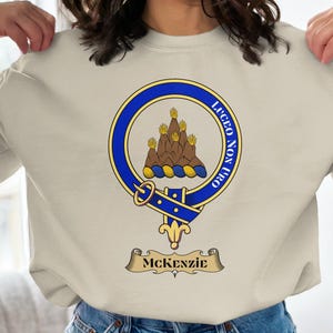 McKenzie clan crest with motto "LUCEO NON URO" on a sweatshirt.