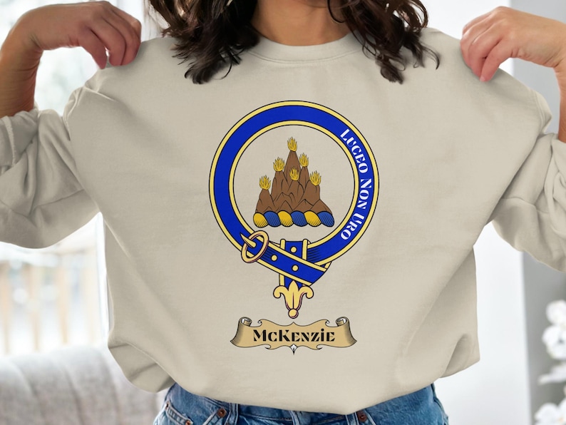 McKenzie clan crest with motto "LUCEO NON URO" on a sweatshirt.