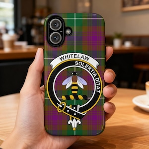 May include: A phone case with a green, purple, and brown plaid pattern. The case features a crest with a bee and the words "WHITELAW SOLERTIA DITAT". The case is designed to fit a smartphone.
