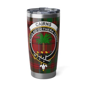 Puede incluir: Un vaso de viaje de acero inoxidable con un patrón de tartán en rojo, verde y marrón. El vaso presenta un escudo con la palabra "CAIRNS" y el lema "VIRTUS AD OETHERA TENDIT". El diseño incluye una palmera y un borde decorativo.