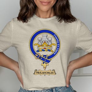 T-shirt with a crest featuring a castle, banner reading "Fortis Et Fidus," and "MCLAUGHLAN" below.