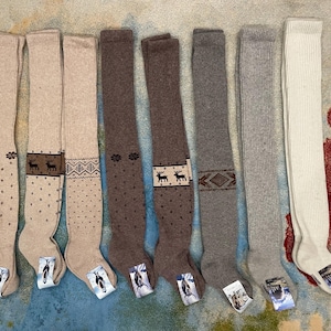Puede incluir: Una colecci&oacute;n de calcetines hasta la rodilla en varios colores, incluyendo beige, marr&oacute;n y gris. Algunos calcetines presentan dise&ntilde;os estampados como lunares, formas geom&eacute;tricas y renos. Los calcetines se muestran sobre una superficie estampada.