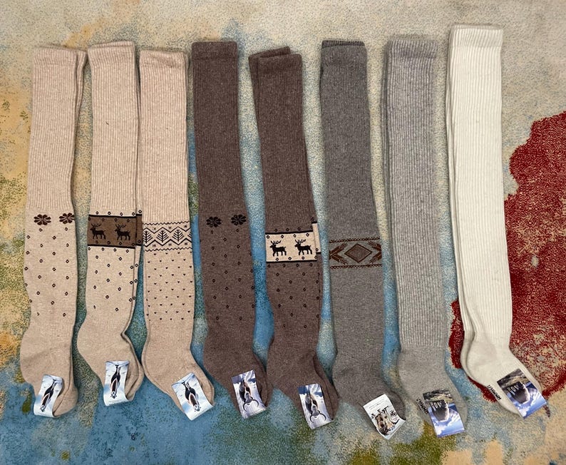 Puede incluir: Una colecci&oacute;n de calcetines hasta la rodilla en varios colores, incluyendo beige, marr&oacute;n y gris. Algunos calcetines presentan dise&ntilde;os estampados como lunares, formas geom&eacute;tricas y renos. Los calcetines se muestran sobre una superficie estampada.