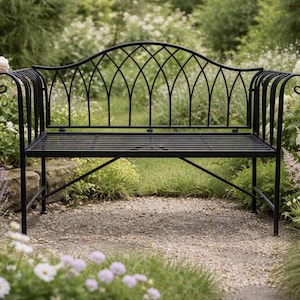 Op de afbeelding: Zwarte smeedijzeren tuinbank met een decoratieve gebogen rugleuning en een lattenzitting. De bank staat te midden van groen en bloemen, waardoor een serene buitenruimte ontstaat. De bank is gemaakt van metaal en is ontworpen voor gebruik buitenshuis.
