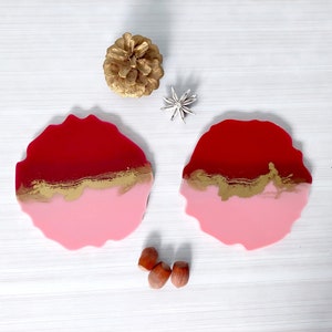 Set mit 2 roten, rosa und goldenen Untersetzern aus Kunstharz