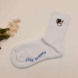 May include: White ankle socks with a blue embroidered angel design and the text "Child of God" on the sole.