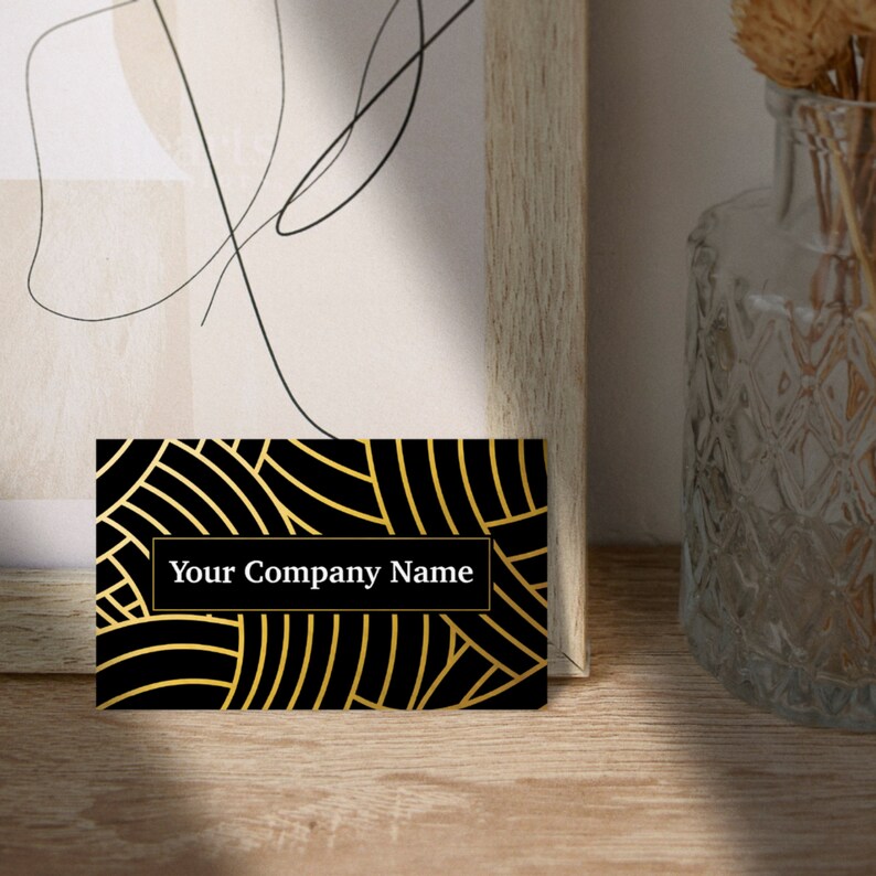 May include: Black and gold business card with a geometric pattern and the text "Your Company Name" in white.