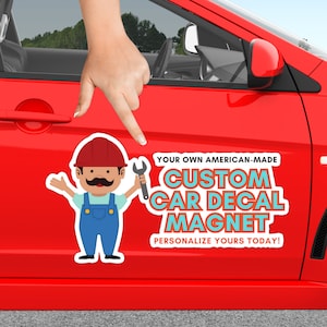 May include: A red car with a custom car decal magnet featuring a cartoon mechanic holding a spanner. The magnet says "Your Own American-Made Custom Car Decal Magnet. Personalize Yours Today!"