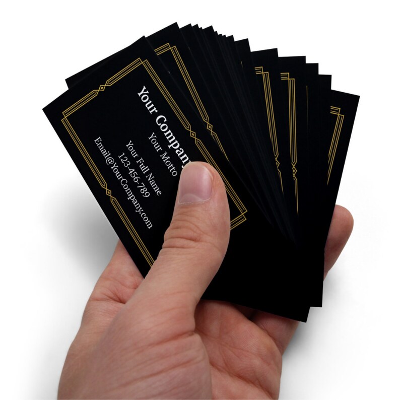 May include: A stack of black business cards with gold trim and white text. The text on the card reads "Your Company", "Your Motto", "Your Full Name", and "Email@YourCompany.com".
