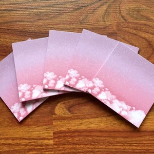 May include: Five pink and white sticky notes with a gradient background and white cloud designs.