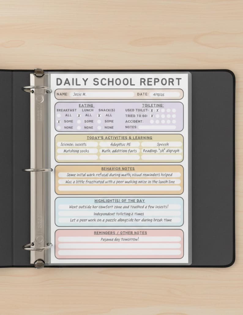 May include: A daily school report form inside a black three-ring binder. The document features sections for eating, toileting, activities, behavior, highlights, and reminders. It includes handwritten text such as Jetic M., 4/12/26, and Pajama day tomorrow.