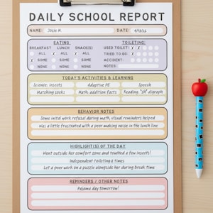 May include: A Daily School Report form on a brown clipboard with a metal clip. The form has sections for eating, toileting, activities, behavior, and notes, with handwritten text including 'Josie M.' and 'Pajama day tomorrow!' next to a blue apple pen.