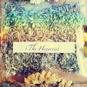 Può includere: Un assortimento di prodotti a base di erbe, tra cui un sacchetto trasparente di erbe essiccate con l'etichetta "The Hexorcist" e due piccole bottiglie di vetro con tappi dorati. Una bottiglia è etichettata "Pour Lift", l'altra "Fast L".