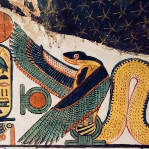 Op de afbeelding: Een kleurrijk schilderij dat een Egyptische godheid afbeeldt met de kop van een havik en het lichaam van een slang. De godheid is afgebeeld met uitgespreide vleugels en een geel slanglichaam. De achtergrond is donkerblauw met witte sterren.