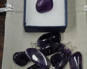 Puede incluir: Una colección de piedras de amatista con anillas de plata, listas para ser convertidas en joyas. Las piedras son de color púrpura intenso y tienen un acabado liso y pulido.