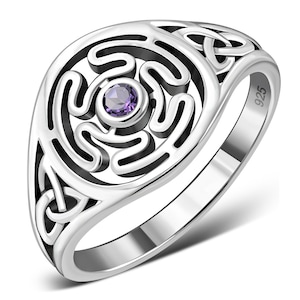 May include: A silver ring featuring a Celtic knot design and a purple gemstone at its centre. The ring is marked "925" on the side.