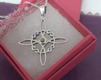 May include: Silver pendant necklace with a Celtic knot design and a green gemstone in the center. The necklace is displayed in a red velvet box.
