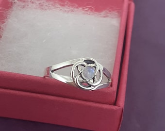 May include: A silver ring with a Celtic knot design and a moonstone center.