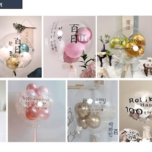 May include: A DIY balloon kit with clear balloons filled with smaller balloons in various colors and designs. The balloons are decorated with text in Korean and English, including "Happy 100 Day" and "Happy 200 Days".