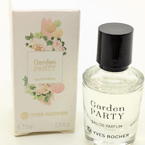 Può includere: Un piccolo flacone di vetro trasparente di Garden Party Eau de Parfum di Yves Rocher. Il flacone è da 5 ml o 0,16 fl oz. Il flacone è in una scatola bianca con un design floreale.