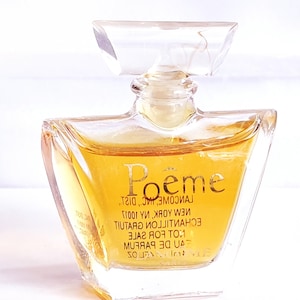 Könnte beinhalten: Eine durchsichtige Glasflasche mit Parfum und einem goldenen Etikett mit der Aufschrift "Poeme Lancome, Inc., Dist., New York, NY 10017. Eau de Parfum. 1 oz. Not for Sale.  Echantillon Gratuit."
