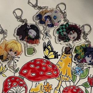 May include: A set of ten colorful keychains featuring anime characters with different designs. The keychains are made of clear acrylic and feature a variety of colors, including red, blue, green, yellow, and black. The keychains are perfect for fans of anime and manga.