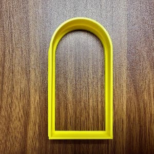 May include: A yellow plastic arch-shaped cookie cutter.