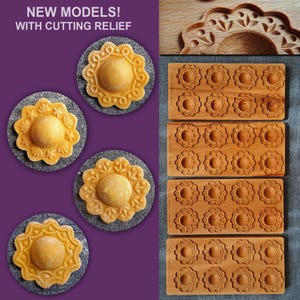 May include: Four wooden cookie cutters with intricate designs, each with a raised center. The cutters are arranged in a row on a wooden surface. The cutters are for making cookies with a decorative edge. The text "NEW MODELS! WITH CUTTING RELIEF" is visible in the image.