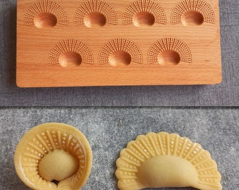 May include: A wooden mold with eight sections for making pasta. The mold has a decorative pattern on each section. Two examples of the pasta made with the mold are shown below.