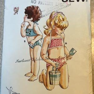 May include: Vintage Kwik Sew pattern 645 for children's swimwear, ages 2-4-6. The illustration shows two girls in swimsuits, one in a blue suit and the other in a red polka dot suit. The pattern is designed by Kerstin Martensson.