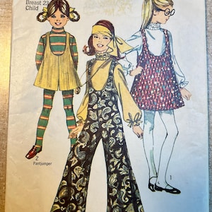 May include: Vintage Simplicity sewing pattern for children's clothing. The pattern features illustrations of three different outfits, including a pantjumper, with the text "Size 4 Breast 23 Child". The pattern is in red and white.