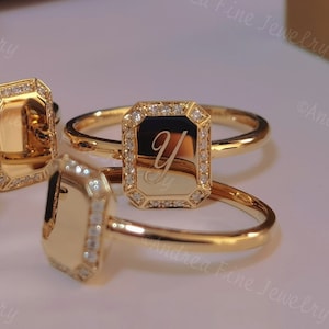 May include: Three gold rings with a square-shaped setting. Each ring has a different design. The first ring has a blank square setting. The second ring has a square setting with the letter "Y" engraved inside. The third ring has a square setting with a small diamond in the centre.