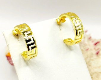May include: A pair of gold hoop earrings with a Greek key design. The earrings are small and delicate.